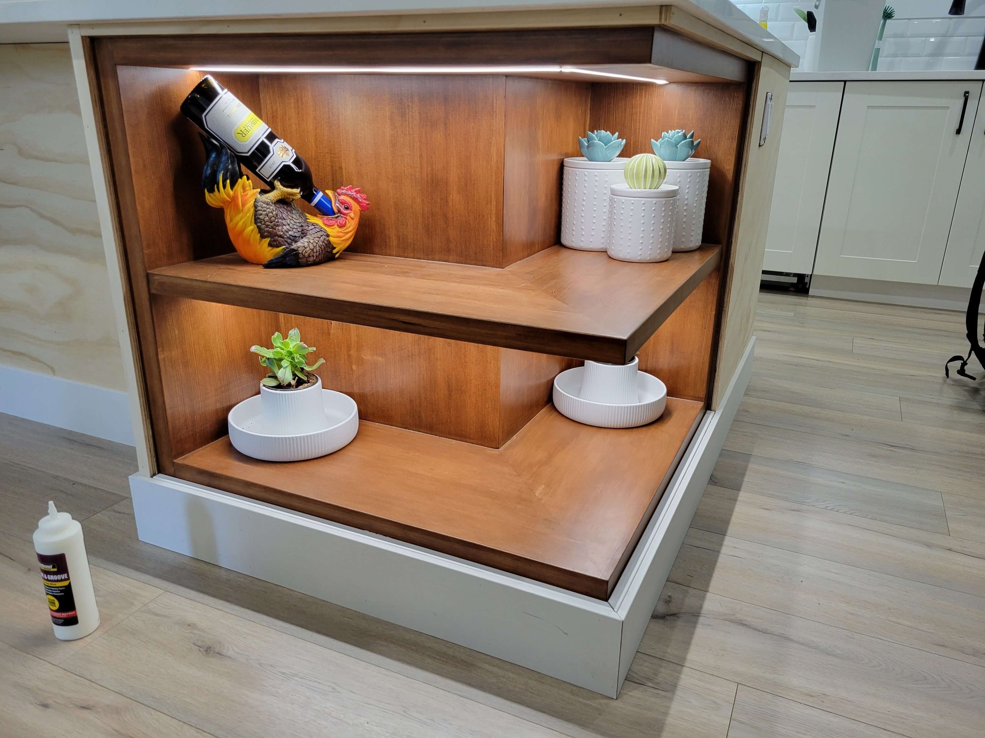 side of kitchen island shelving piece with wine holder and jars with lighting