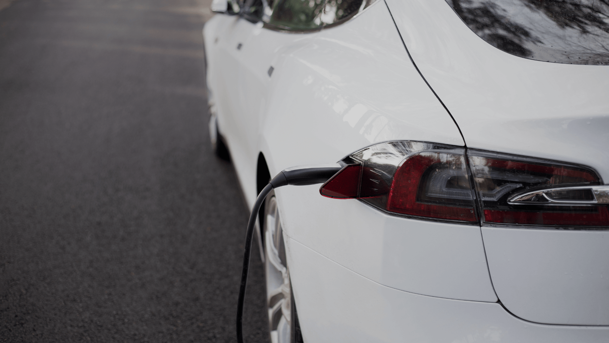 EV charger plugged into white electric car for charging