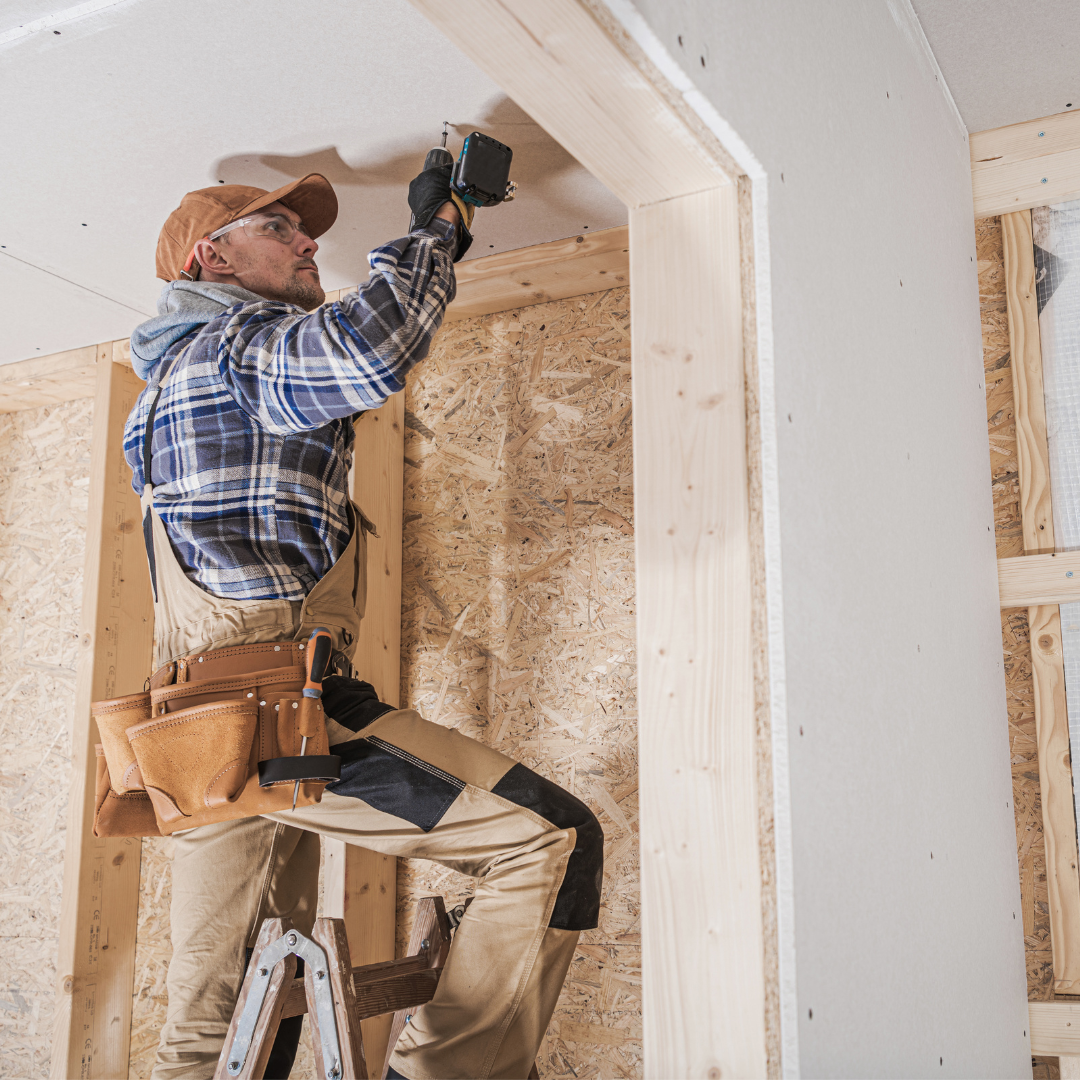langley electrician with plaid shirt and overalls drilling into ceiling